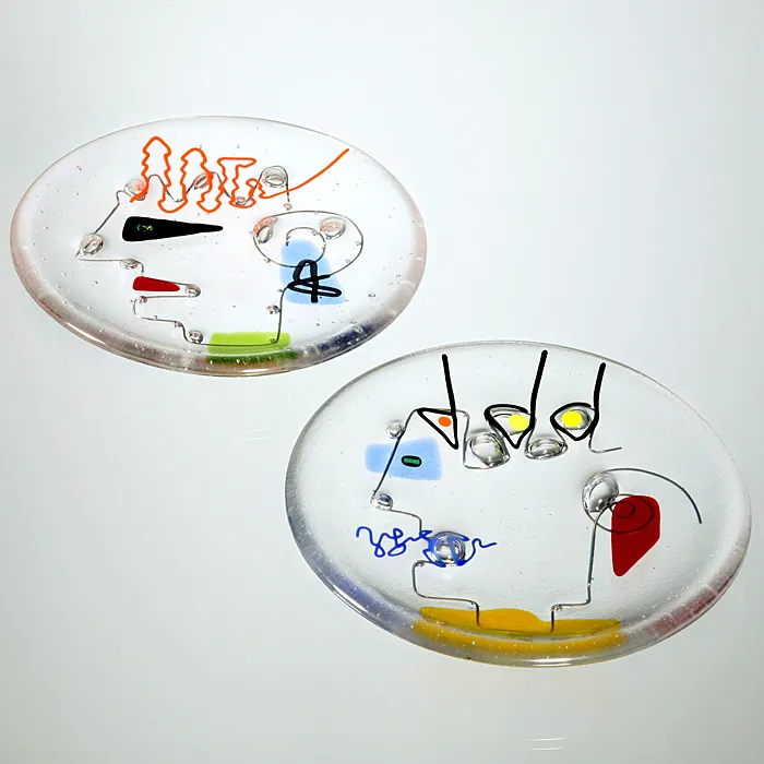Runder Glasteller mit farbigen Linien und Flächen